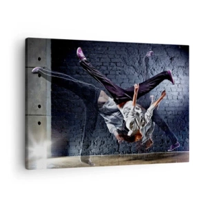 Tablou pe pânză Canvas - Un dansator într-o săritură dinamică pe un zid de cărămidă - 70x50cm - Steaua străzii - Decorațiune modernă pentru perete pentru living și dormitor ARTTOR