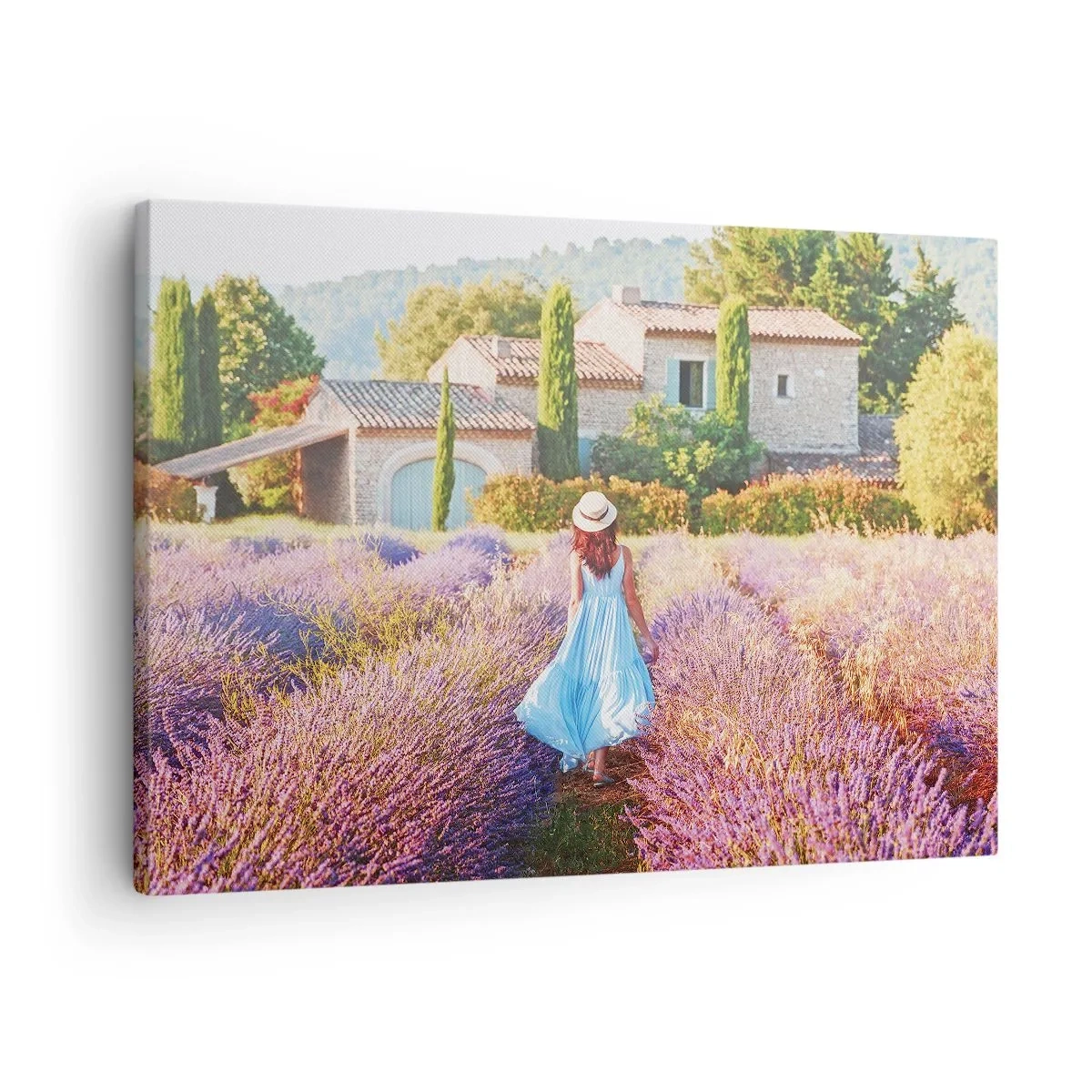 Tablou pe pânză Canvas - O femeie într-o rochie albastră se plimbă printr-un câmp de lavandă cu vedere la o casă. - 70x50cm - Fata de lavandă - Decorațiune modernă pentru perete pentru living și dormitor ARTTOR
