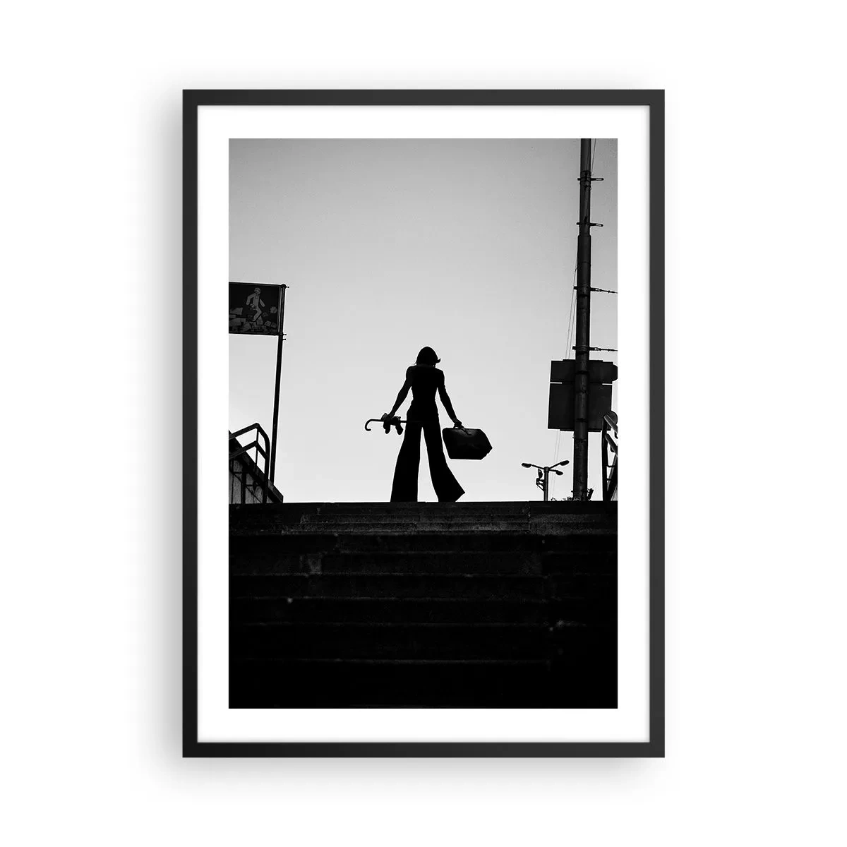 Poster în ramă neagră - Silueta unei femei cu o valiză pe fundalul apusului de soare - 50x70cm - Rătăcire urbană - Decorațiune modernă pentru perete pentru living și dormitor ARTTOR