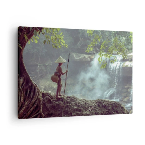 Tablou pe pânză Canvas - O figură cu o suliță la o cascadă într-o pădure tropicală - 70x50cm - Prietenul naturii - Decorațiune modernă pentru perete pentru living și dormitor ARTTOR