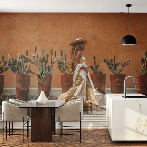 Tapet Standard Eco - O femeie în stil boho pe fundalul unor ghivece cu cactuși și al unui perete portocaliu. - 100x70cm - În stilul hippie - Decorațiune modernă pentru perete pentru living și dormitor ARTTOR