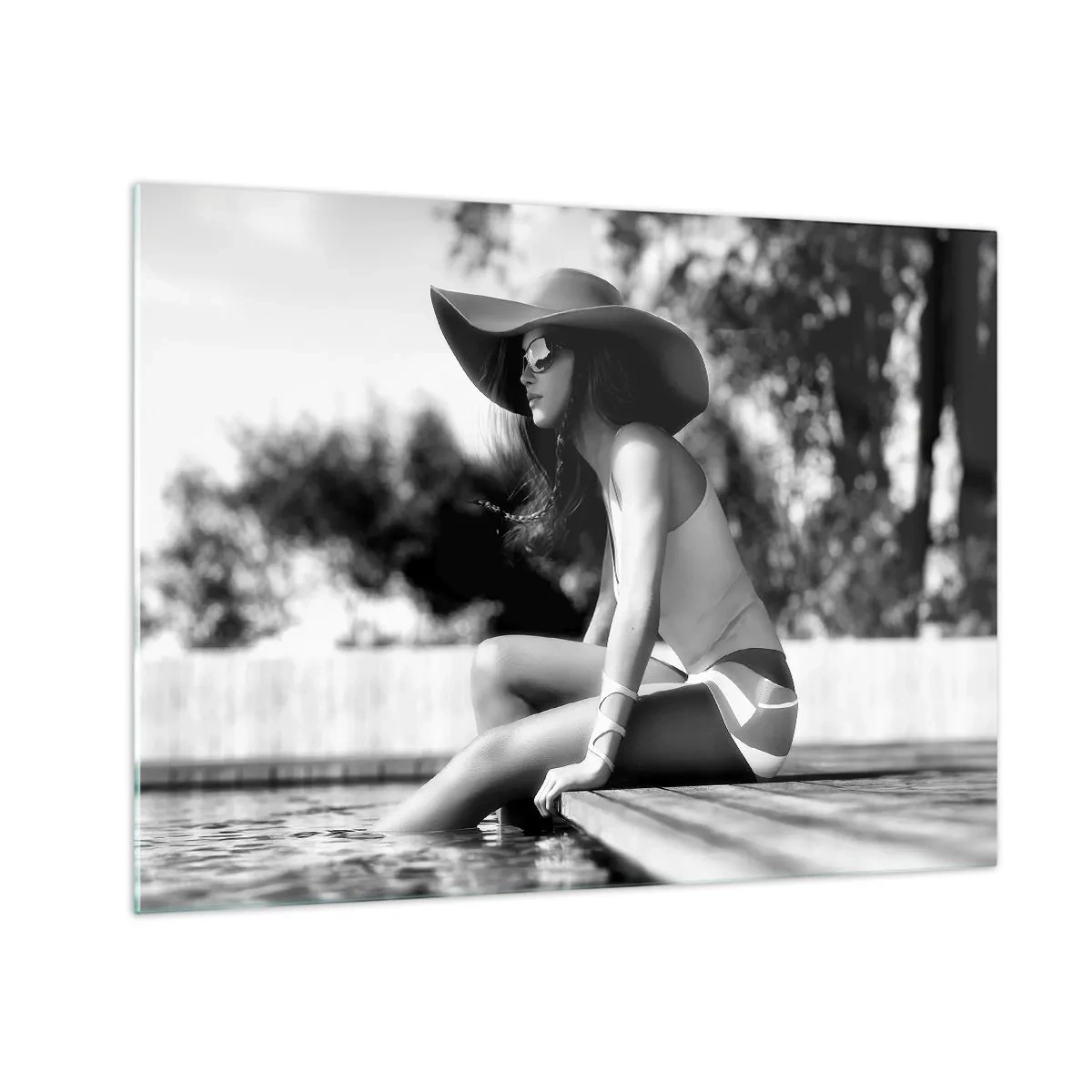 Tablou pe sticlă - Femeie purtând o pălărie stând lângă piscină în alb și negru - 70x50cm - Vis de vară - Decorațiune modernă pentru perete pentru living și dormitor ARTTOR