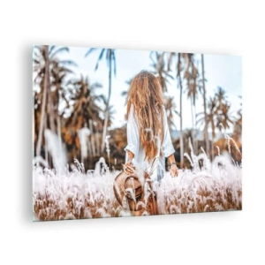 Tablou pe sticlă - O femeie în iarbă cu o pălărie în mână pe un fundal de palmieri - 70x50cm - Născută din puful de iarbă - Decorațiune modernă pentru perete pentru living și dormitor ARTTOR