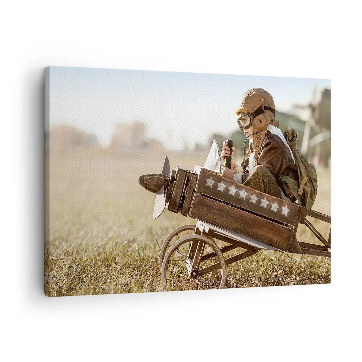 Tablou pe pânză Canvas - Un copil într-un avion de jucărie cu un câmp în fundal - 70x50cm - Porniți spre vis - Decorațiune modernă pentru perete pentru living și dormitor ARTTOR