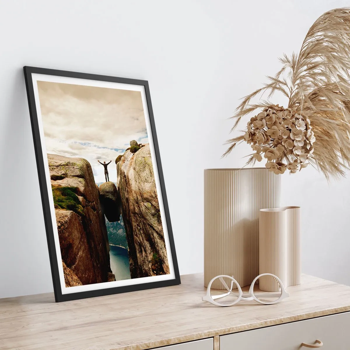 Poster în ramă neagră - Un bărbat stând pe o stâncă suspendată între stânci - 50x70cm - Cum mă simt!? - Decorațiune modernă pentru perete pentru living și dormitor ARTTOR