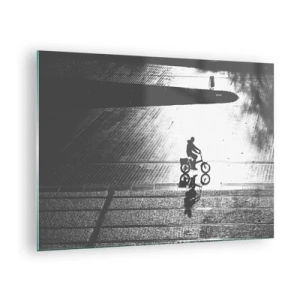 Tablou pe sticlă - Bărbat mergând cu bicicleta prin oraș, reflexie în apă, fotografie alb-negru - 70x50cm - Înainte, prin oraș - Decorațiune modernă pentru perete pentru living și dormitor ARTTOR