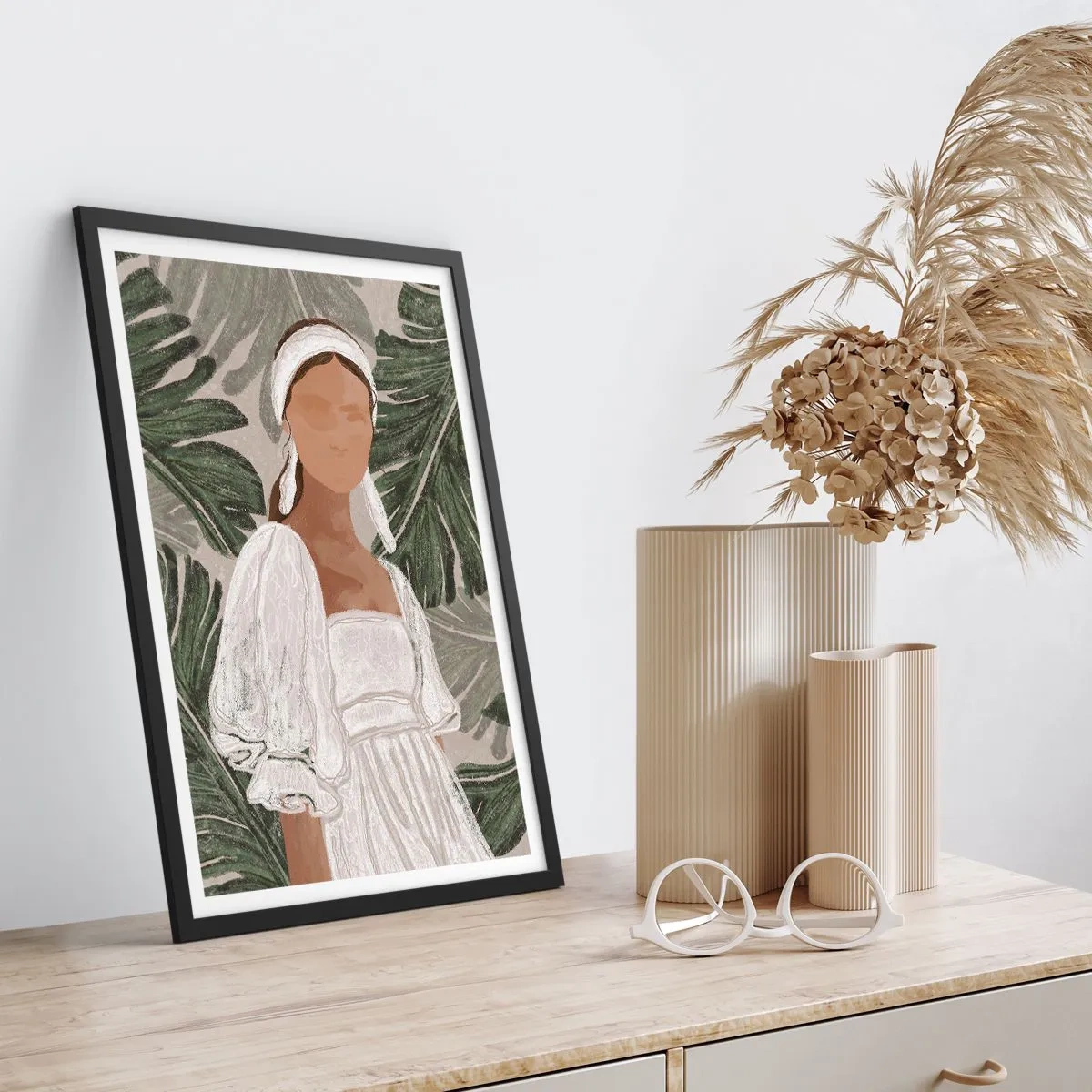 Poster în ramă neagră - O femeie într-o rochie albă pe un fundal de frunze verzi - 50x70cm - Portret exotic - Decorațiune modernă pentru perete pentru living și dormitor ARTTOR