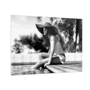 Tablou pe sticlă - Femeie purtând o pălărie stând lângă piscină în alb și negru - 70x50cm - Vis de vară - Decorațiune modernă pentru perete pentru living și dormitor ARTTOR