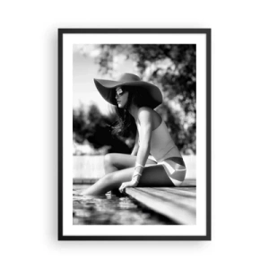 Poster în ramă neagră - O fotografie alb-negru a unei femei purtând o pălărie, stând lângă apă. - 50x70cm - Vis de vară - Decorațiune modernă pentru perete pentru living și dormitor ARTTOR