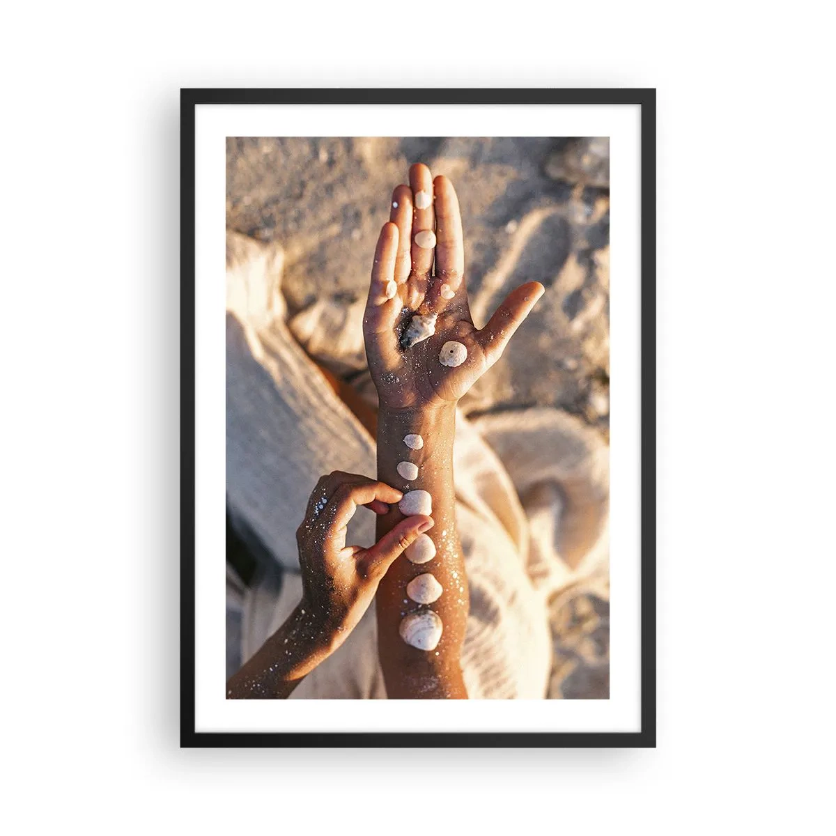 Poster în ramă neagră - Mâini decorate cu scoici pe un fundal nisipos - 50x70cm - Frumusețe la îndemână - Decorațiune modernă pentru perete pentru living și dormitor ARTTOR