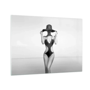 Tablou pe sticlă - O femeie într-un costum de baie negru și o pălărie pe fundalul mării - 70x50cm - Numele meu este: Eleganța - Decorațiune modernă pentru perete pentru living și dormitor ARTTOR