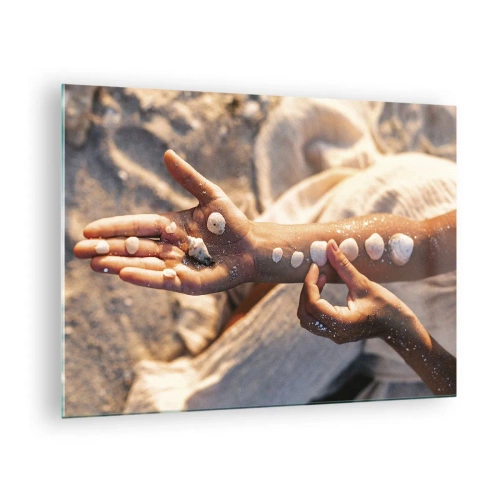 Tablou pe sticlă - Mâinile unui copil cu scoici pe un fundal de nisip și material textil - 70x50cm - Frumusețe la îndemână - Decorațiune modernă pentru perete pentru living și dormitor ARTTOR